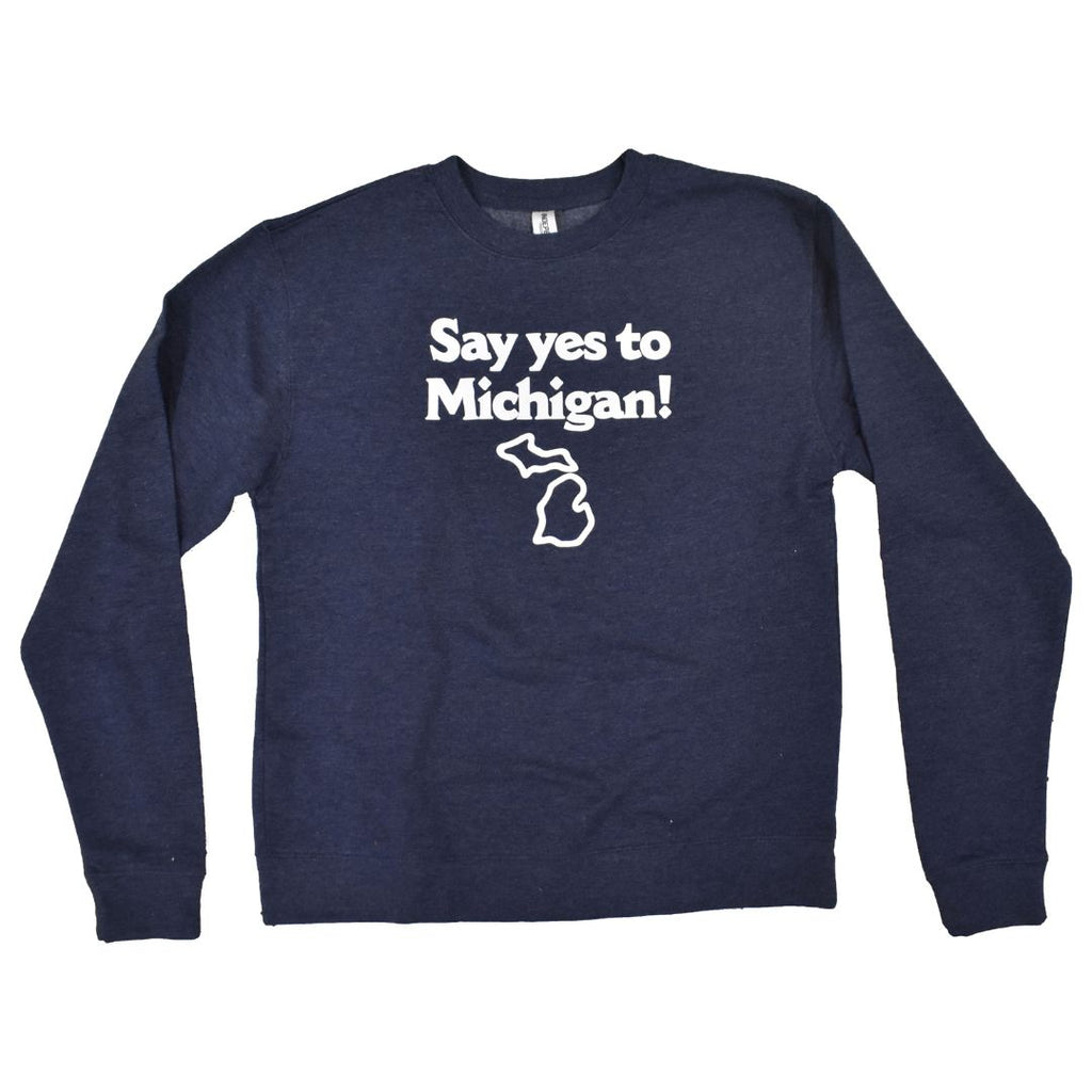 A navy blue crewneck sweatshirt with a white logo on the chest that reads “Say yes to Michigan!” with an outline of the state of Michigan underneath it.
