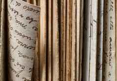 Several folders and loose papers vertically stored with one piece pulled slightly out from the others.