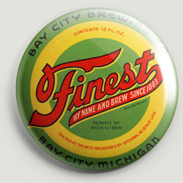 The front of a round bottle opener magnet featuring the beer label for Finest Beer. Text on the label reads “Finest by Name and Brew Since 1883 Bay City Brewing Co. Bay City, Michigan” and features red, black, and white text on a green and yellow background.