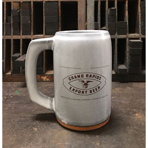 A light gray ceramic stein with the label for Grand Rapids Export Beer produced by Grand Rapids Brewing Company imprinted on the front.