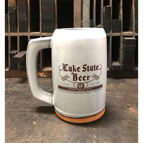 A light gray ceramic stein with the label for Lake State Beer produced by Grand Rapids Brewing Company imprinted on the front.