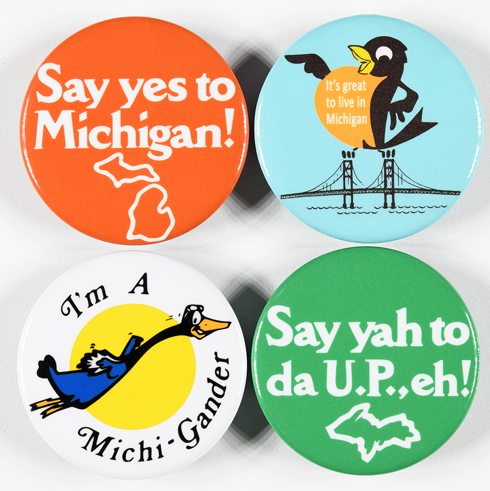 The fronts of four round bottle opener magnets featuring the logo for “Say yes to Michigan!” in bold white text with a white outline of Michigan underneath it on an orange background, the logo for “Say yah to da U.P., eh!” in bold white text with a white outline of the Upper Peninsula underneath it on a green background, a cartoon goose on a white background with the text “I’m a Michi-Gander,” and the Proud Robin “It’s Great to Live in Michigan” logo on a light blue background.