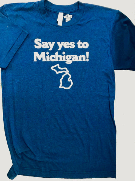 Front of a blue t-shirt featuring the text in white lettering “Say yes to Michigan!” with a white outline of the state of Michigan beneath it.