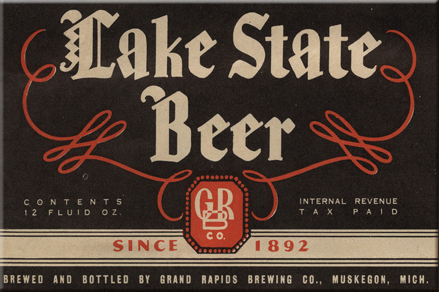 Beer label for Lake State Beer featuring text in white and red on a black background. Text reads “Lake State Beer Since 1892 Brewed and Bottled by Grand Rapids Brewing Co., Muskegon, Mich. Contents 12 Fluid Oz. Internal Revenue Tax Paid”